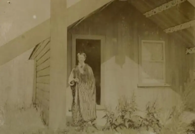 Image: [Goldie Wearing a Kahu Standing in Front of Whare ...]