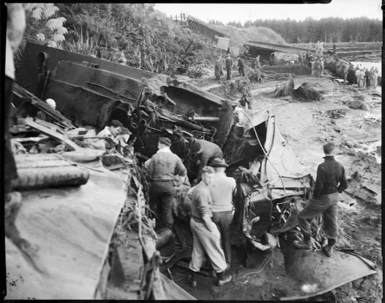 Image: Men alongside wrecked railway carriages alongside the Whangaehu Stream, at the scene of the railway disaster at Tangiwai
