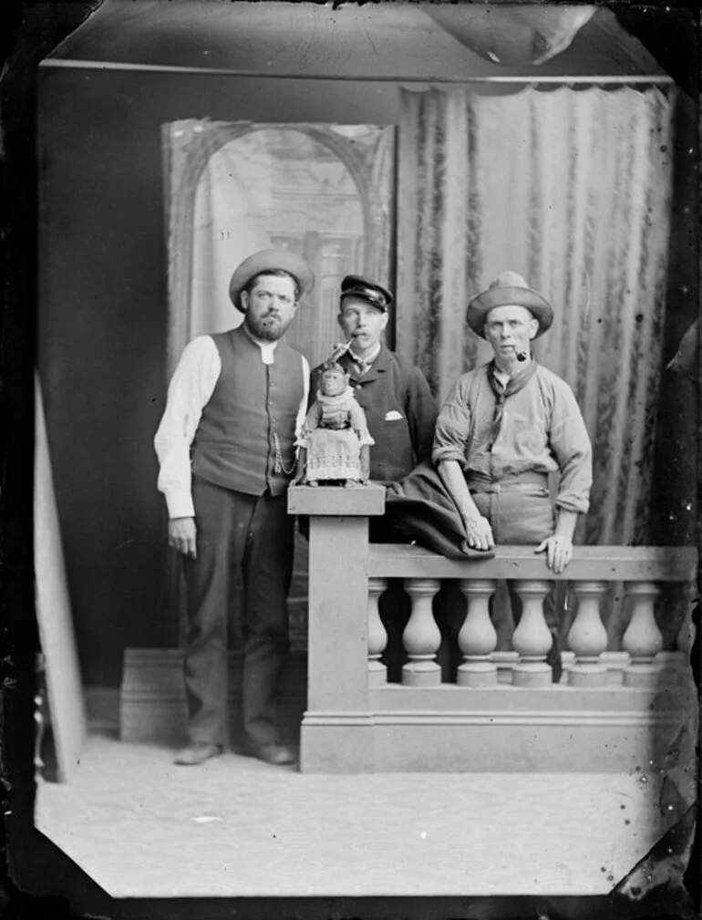 Image: Unidentified men, with a pet monkey