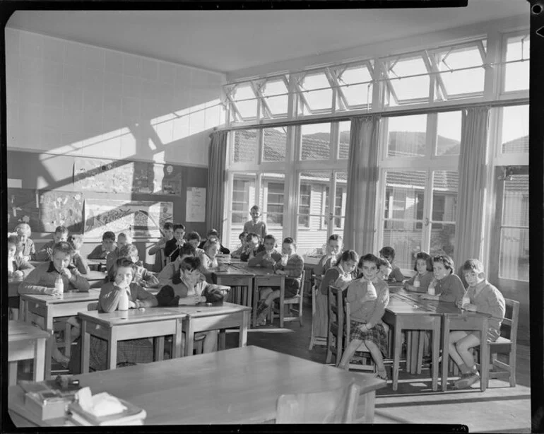 Image: Children at desks in classroom drinking milk through straws