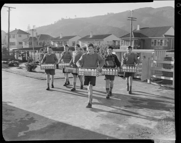 Image: Schoolboys carrying crates of milk across school ground