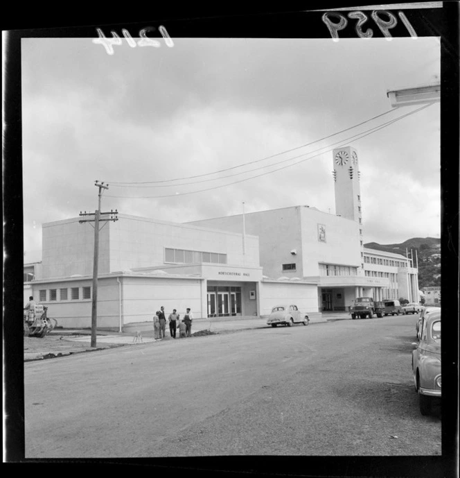 Horticultural Hall and Town Hall, Lower Hutt, Wellington Region, including parked cars and unidentified workers [from Wilkins & Davies?] on Laings Street