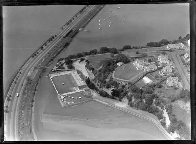 Close-up view of Parnell Baths, Auckland City, showing Point Resolution Park, Tamaki Drive and railway, Judges Bay with Albert Park House (Albert Barracks) and residential housing, Hobson Bay beyond
