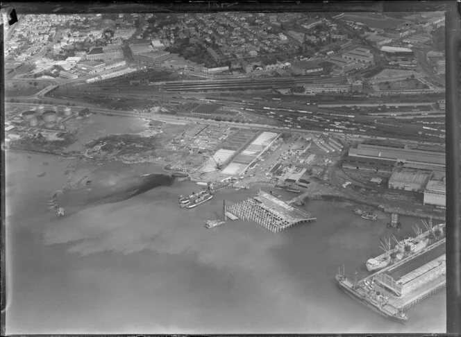 Cargo ships, stacks of timber and car ferry, wharf for exports, Auckland