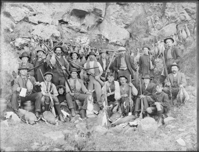 Group of unidentified bird and rabbit hunters, probably Christchurch district, showing men and boys with their catch and rifles