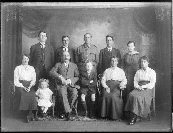Studio family portrait, unidentified older couple with adult family and [partners?], and grandchildren, with one man in soldiers uniform, Christchurch