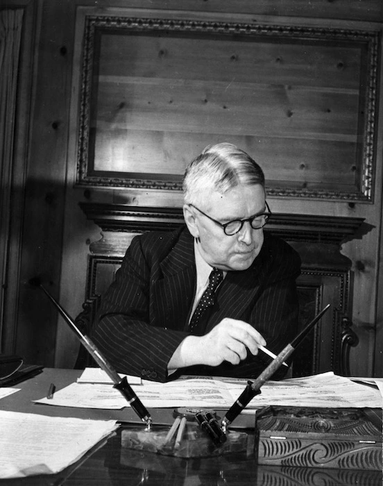 Walter Nash sitting at his desk in the legation chancery, Washington