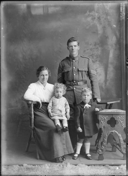 Studio portrait of unidentified soldier in uniform, woman and two young children, probably Christchurch district