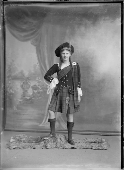 Studio portrait of an unidentified Highland dancer, showing a girl wearing traditional Scottish costume