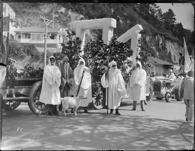 New Napier Week Carnival, trailer float with Stonehenge megalithic type arches, men dressed as Druids standing in front with goat, Napier, Hawke's Bay District