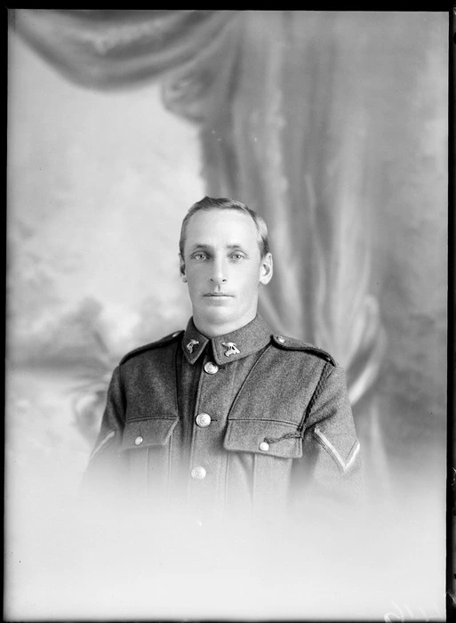 Studio upper torso portrait of unidentified Lance Corporal World War I soldier with [Tui or Huia?] 'NXXIZ' collar badges and dark shoulder webbing attached to left side lapel pocket, Christchurch