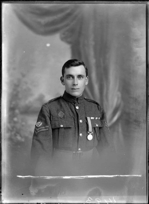 Studio portrait of an unidentified young man dressed in a military uniform decorated with a medal [with the rank of corporal?], possibly Christchurch district