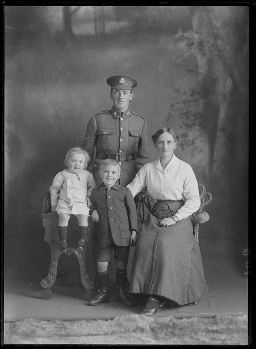 Studio unidentified family portrait, World War I Lance Corporal soldier with star collar [Army Service Corps?] and hat badges [Reinforcements?], with wife, young son and daughter, Christchurch