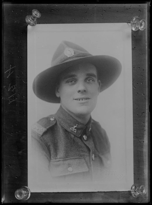 Studio upper torso portrait of an unidentified young World War I soldier with NZR shoulder badges and heron collar and lemon squeezer hat badges, location unknown