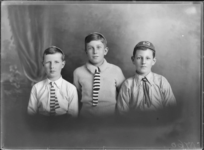 Studio upper torso portrait of three unidentified young boys in caps with 'Avon Rowing Club' badges and striped ties, Christchurch