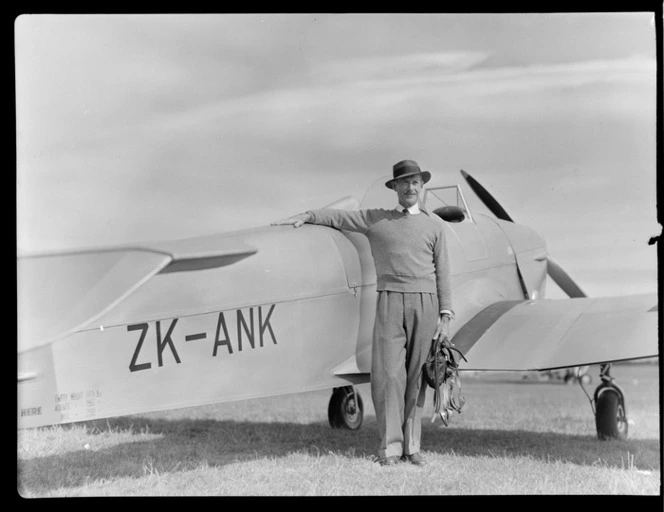 John Gamble standing next to a Miles Magister aeroplane, ZK-ANK, at RNZAC Pageant, Dunedin