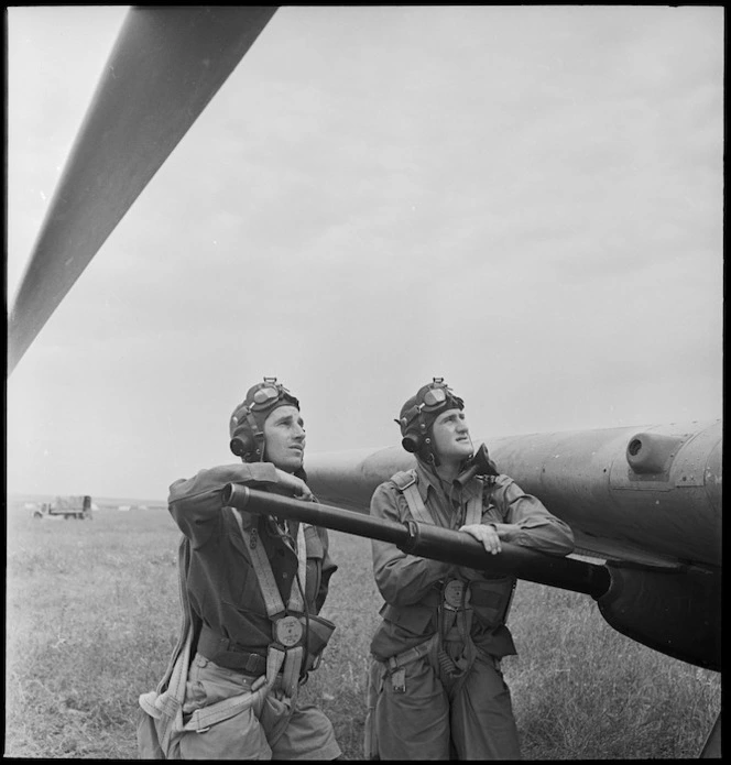 Pilot Officer Paton and Sergeant Pilot Crompton leaning on the barrel of a gun on a tank buster, Tunisia, World War II - Photograph taken by M D Elias