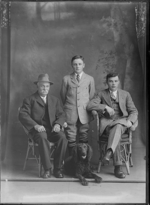 Studio portrait of an unidentified elderly man with a moustache, and two youths, with a dog, probably Christchurch district