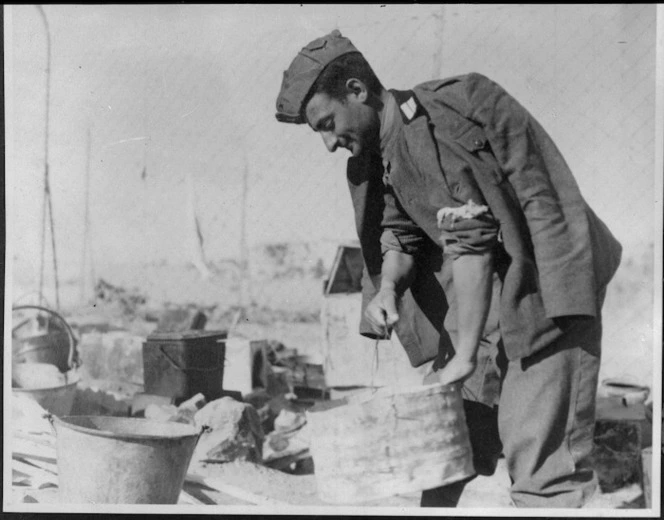 Italian POW in Tobruk prepares a meal for his fellows, World War II