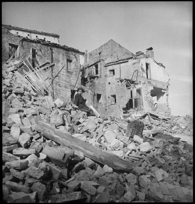 Italian girl sitting among ruins of her home in Atessa, Italy, World War II - Photograph taken by George Kaye