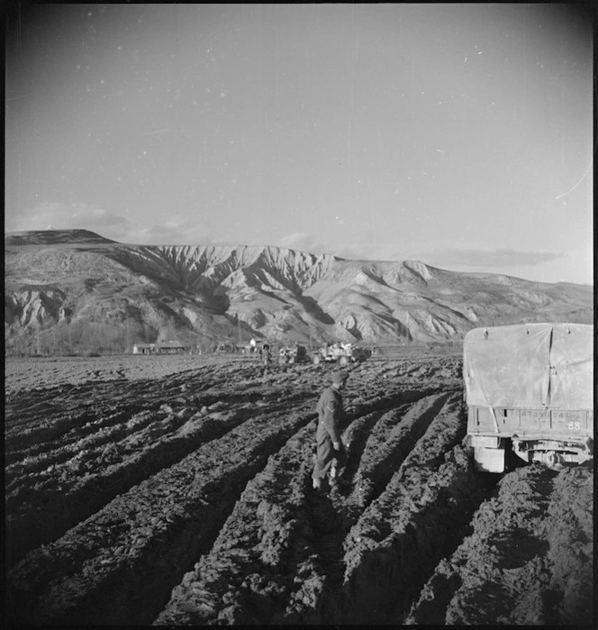 View of flat country on northern side of Sangro River cut up by NZ Division vehicles and hills in background, Italy - Photograph taken by George Kaye