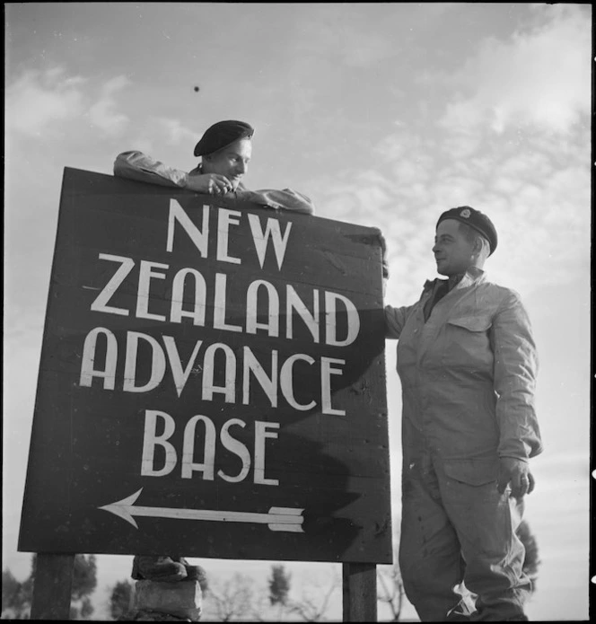 J A Smith and Volkerling around the sign to the New Zealand Advance Base Camp, Italy, World War II - Photograph taken by M D Elias
