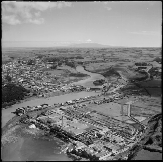 The coastal town of Patea and the Patea Freezing Works in the foreground with rail yards and the West Coast Refrigeration Co Ltd factory alongside the Patea River, South Taranaki Region