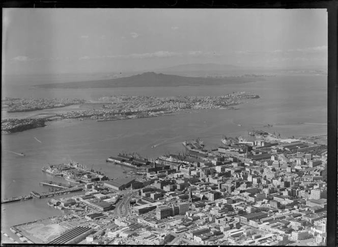 Auckland city centre with the Ports of Auckland wharves and harbour entrance, with Devonport and Rangitoto Island beyond, Auckland City