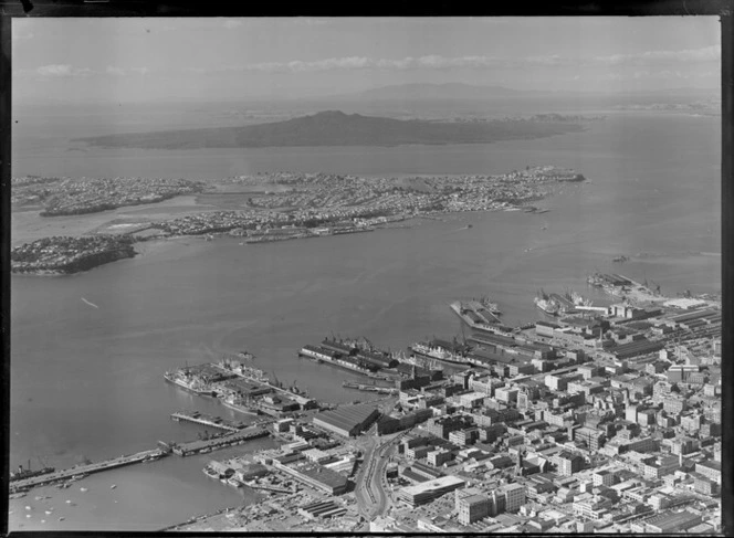 Auckland city centre with the Ports of Auckland wharves and harbour entrance, with Devonport and Rangitoto Island beyond, Auckland City