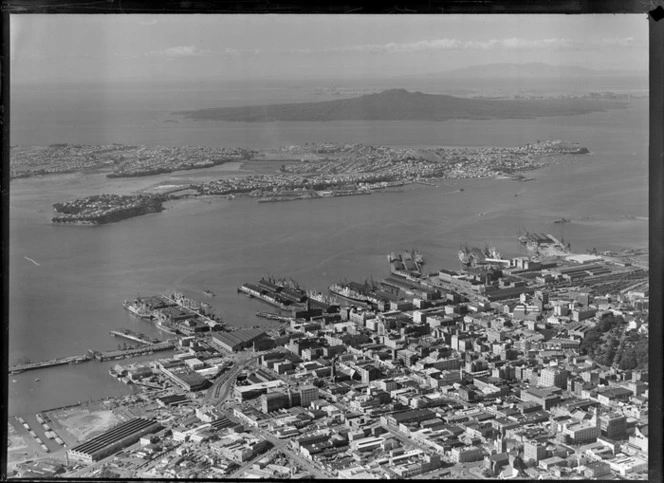 Auckland city centre with Albert Park and the Ports of Auckland wharves and harbour entrance, with Devonport and Rangitoto Island beyond