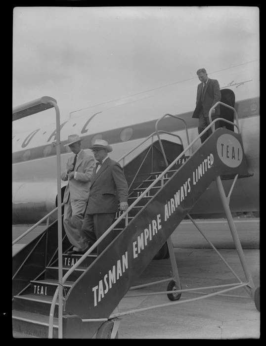 Mr J H Luxford Mayor of Auckland and Mr W Essex of Canadian Pacific Airlines on gangway of TEAL Comet aircraft with unidentified man behind, Whenuapai, Auckland Region