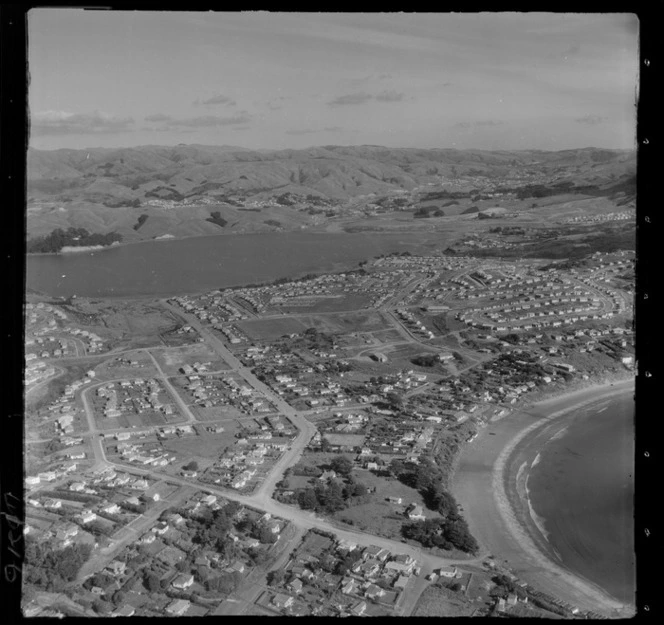 Titahi Bay housing development with Bay Drive and Main Road with Kura Park running to Porirua Harbour beyond, Wellington Region