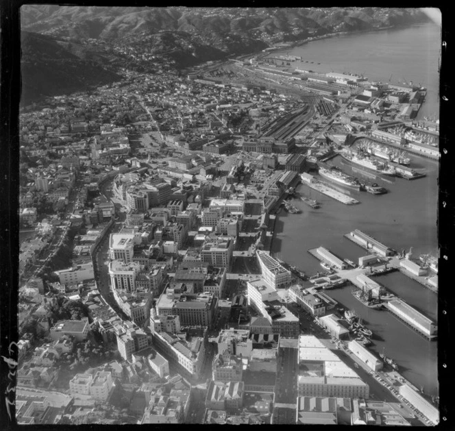 Wellington City with Lambton Quay, Customhouse Quay and Waterloo Quay with wharves, to Wellington Railway Station with rail yards and Thorndon residential area