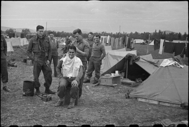 Private A Forbes gives Private E L Newlove a haircut at the NZ LOB Camp near Capua, Italy, World War II - Photograph taken by George Bull