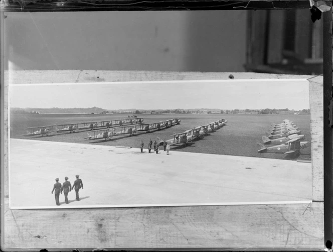 Rows of de Havilland DH 82 Tiger Moth biplanes, at an unidentified aerodrome, with unidentified military personnel on tarmac alongside
