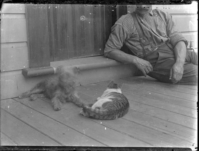 Man on verandah with dog and cat - taken by an unknown photographer