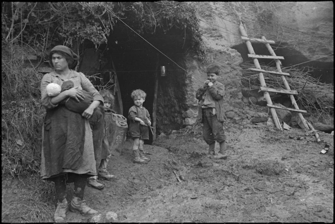 Civilian family outside cave in which they now live after their home was demolished by the Germans, Italy, World War II - Photograph taken by George Kaye
