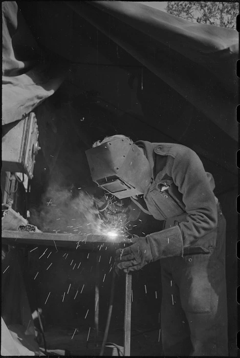 H P Partington does an electric welding job at NZ Divisional Field Workshops, Cassino Front, World War II - Photograph taken by George Kaye