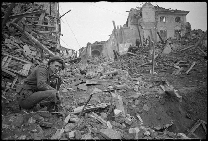 New Zealand soldier using a telephone in war damaged Faenza, during World War II