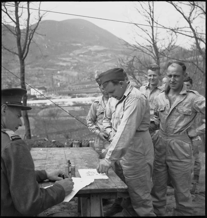 Corporal R Stark takes a Mepacrine antimalarial tablet under the supervision of Major H T Knights, Italy, World War II - Photograph taken by M D Elias