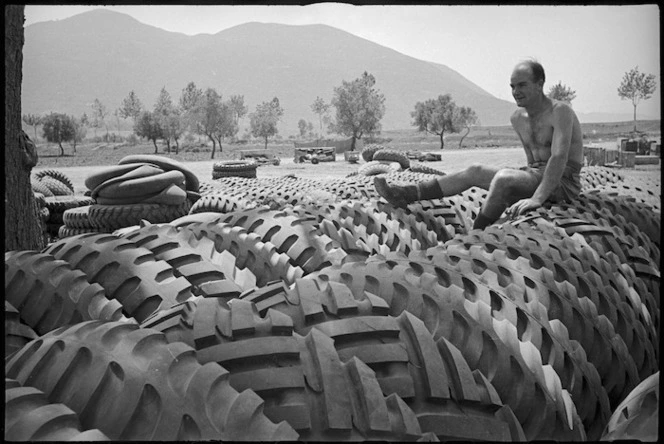 T Ford rests on some of the large tyres for 2 NZ Division vehicles on the Cassino Front, Italy, World War II - Photograph taken by George Kaye