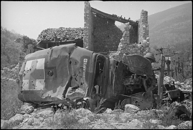 Wrecked ambulance lies outside the ruins of Cassino, Italy - Photograph taken by George Kaye