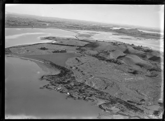 View of the Kellihers' Puketutu Island farm and road access causeway with Mangere and Manukau City beyond, Manukau Harbour, South Auckland