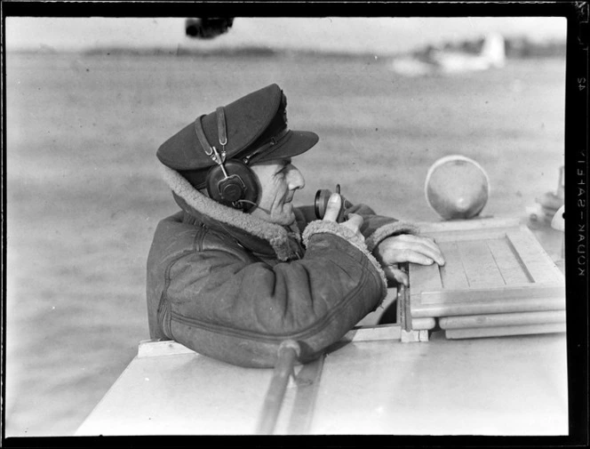Flying Control Room, Mechanics Bay, Auckland, showing the Control Officer using a microphone and headphone set aboard a boat
