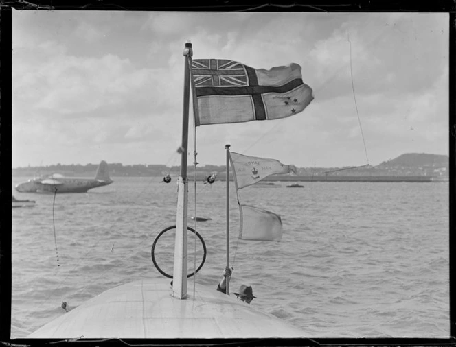 View of a TEAL home flag and a Royal Air Mail flag flying on top of the TEAL Short Empire Flying Boat 'Awarua', Mechanic's Bay, Auckland Harbour
