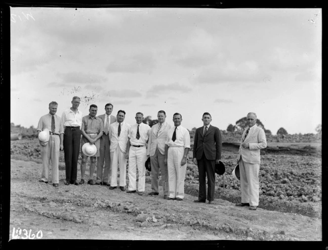 Group of men, including Group Captain HWL Saunders, CAS, and W Lee, PWD, at construction site of Nausori International Airport, Fiji