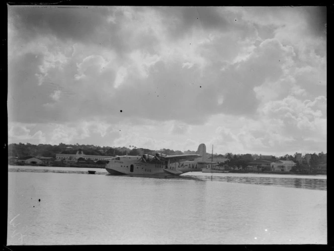 Tasman Empire Airways Ltd Short Empire flying boat ZK-AMA 'Aotearoa, moored in harbour, Suva, Fiji, including buildings surrounding harbour