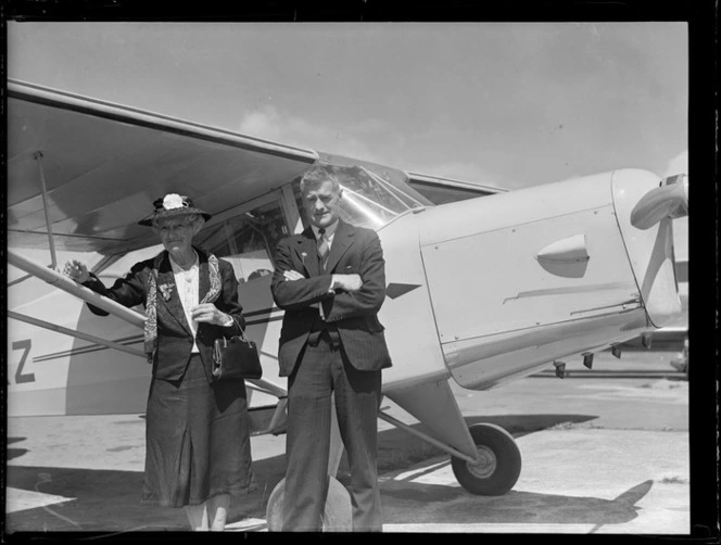 Dr H K Christie and his mother of Wanganui standing by an Auster aircraft, Mangere