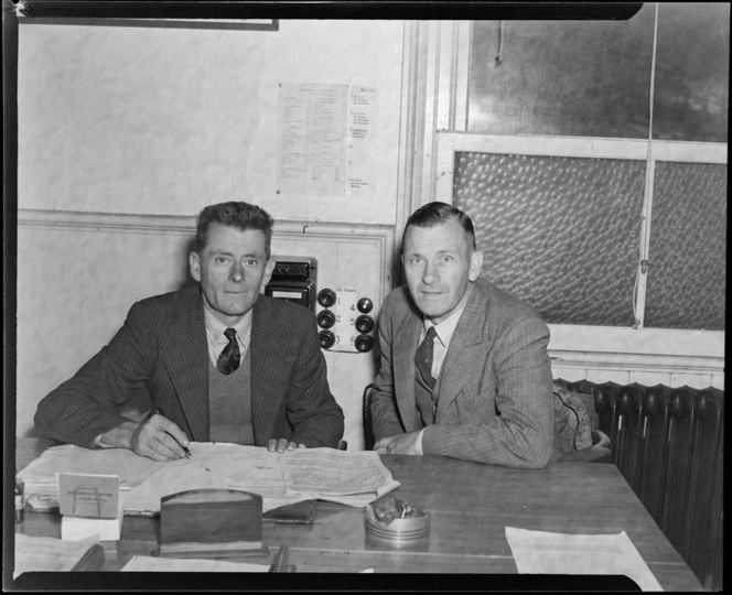 Portrait of Doctor Haskell (PhD) an aerodromes engineer and Bill Lee, at a desk within an unidentified office, Wellington