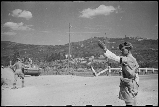 New Zealand Divisional Provost, I A Walker, directs NZ transport on way to Arezzo, Italy, World War II - Photograph taken by George Kaye